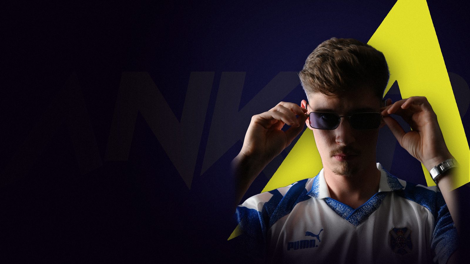 Ankar Sánchez ajustándose las gafas, con la A del logo detrás